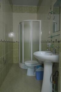 a bathroom with a shower and a toilet and a sink at Prime Villa Hotel in Tashkent