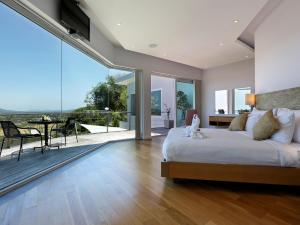 1 dormitorio con 1 cama grande y balcón en Villa Namaste 7 Bedroom Fully Staffed Seaview Villa, en Bang Tao Beach