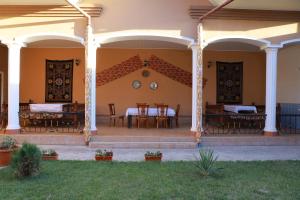 a porch of a house with tables and chairs at Prime Villa Hotel in Tashkent