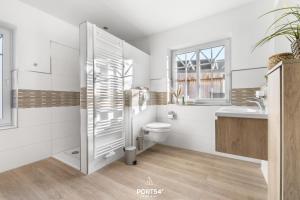 a bathroom with a shower and a toilet and a sink at Ferienhaus Buhne 23 in Büsum