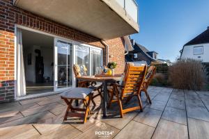 a wooden table and chairs on a patio at Ferienhaus Buhne 23 in Büsum