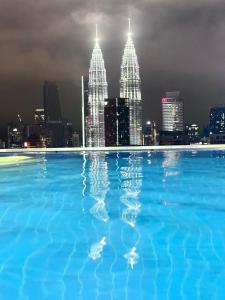 a swimming pool with a city skyline at night at THE LUXE INFINITUM RESIDENCE at KL CITY in Kuala Lumpur