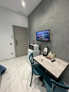a room with a table and a tv on a wall at Fly Home 2 in Naples +22 photos