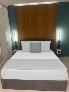 a large white bed with two pillows in a room at Luxury high-tech apartment in Larisa
