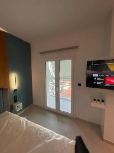 a bedroom with a large window and a tv at Luxury high-tech apartment in Larisa