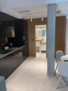 a kitchen with black cabinets and a table and chairs at Luxury high-tech apartment in Larisa