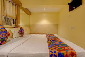 a bedroom with a bed with a colorful comforter at FabHotel Starwood Residency - Behind BMW Car Showroom in Navi Mumbai +29 photos