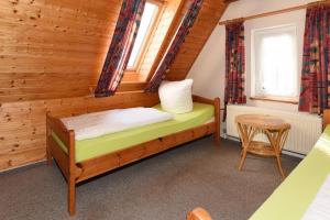 a bedroom with a bed and a table in a room at Haus Kajedeich FeWo Robbe in Bensersiel