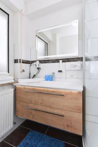 a bathroom with a white sink and a mirror at Haus zur Möwe FeWo Möwe 2 in Bensersiel