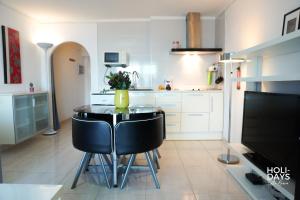 a kitchen with a table and two black chairs at Holidays 15K Empuriabrava in Empuriabrava