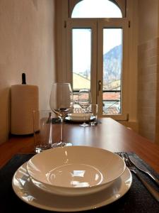 a table with a plate and two wine glasses on it at Comfy apartment in Lecco 2 in Lecco