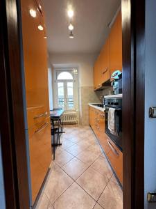 a kitchen with orange cabinets and a table in it at Comfy apartment in Lecco 2 in Lecco