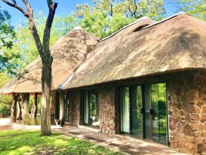 SimunyeMbuluzi Game Reserve的一座带茅草屋顶的古老石头房子