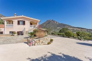 a house with a mountain in the background at Domu Elgive in Tertenìa