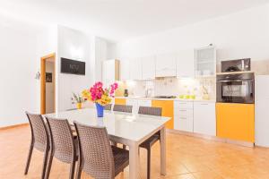 a kitchen with a table with chairs and flowers on it at Domu Elgive in Tertenìa +19 photos