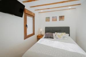 a bedroom with a bed with a tv on the wall at La Casa De Sara in Llánaves de la Reina