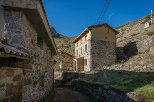 an old stone building next to a mountain at La Casa De Sara in Llánaves de la Reina