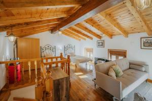 a living room with wooden ceilings and a couch at La Casa De Sara in Llánaves de la Reina