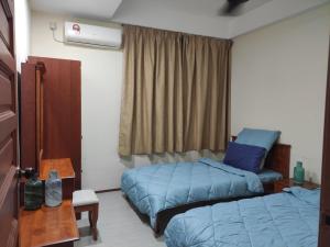 ジョージタウンにあるJomStay At Georgetownのベッド2台とテーブルと窓のある寝室