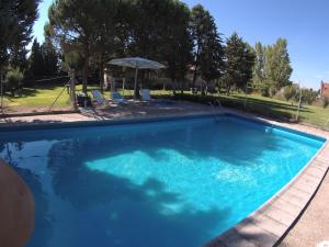 a swimming pool with blue water in a yard at La Casa de Arroyo in Arroyo de Cuéllar