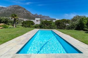 a swimming pool in the backyard of a house at Beachfront Villa Sea Breeze Hout Bay Cape Town in Hout Bay