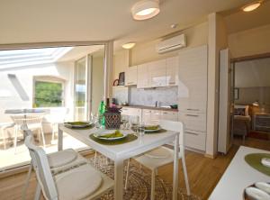 a kitchen and dining room with a white table and chairs at Tranquil Getaway with Shared Pool in Bale in Bale