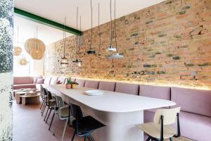 a dining room with a white table and pink chairs at Villa Plage Ensorpark in Ostend