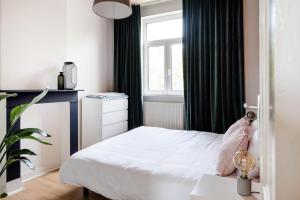 a small bedroom with a bed and a window at Villa Plage Ensorpark in Ostend