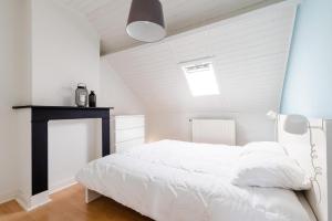a bedroom with a white bed with a blue ceiling at Villa Plage Ensorpark in Ostend +102 photos