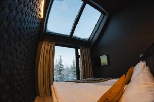a bedroom with a large window and a bed at Hotel Ylläsrinne Deluxe in Ylläsjärvi