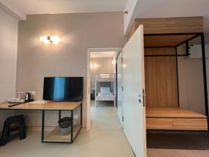 a room with a desk and a computer and a bedroom at Serapi Verdure Hotel in Kuching