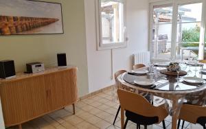 a dining room with a table and some chairs at Maison Centre ville avec Jacuzzi in La Teste-de-Buch