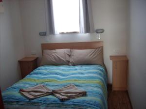 1 cama con 2 toallas en un dormitorio en Jacko's Holiday Cabins en Arno Bay