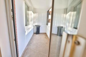 a hallway with two windows and two trash cans at Meersinn Ferienwohnung Brake in Harrierwurp