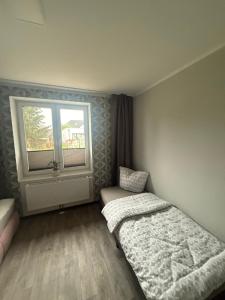 a small bedroom with a bed and a window at Ferienwohnung Parkentin 3 in Bartenshagen-Parkentin
