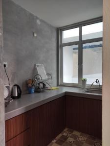 ジョージタウンにあるJomStay At Georgetownのシンクと窓のあるキッチン