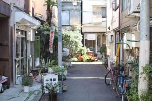 an alley with plants and bikes parked on a street at hanare in Tokyo
