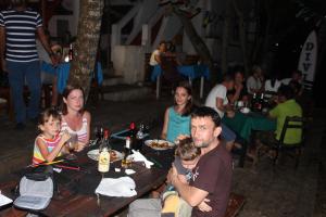 a group of people sitting at a table with food at Natures Bliss Garden Stay in Ja-Ela