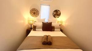 a bedroom with a bed with two slippers on it at Zulu Sunset Luxury Apartment in St Lucia