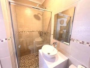 a bathroom with a toilet and a sink and a shower at Zulu Sunset Luxury Apartment in St Lucia