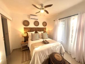 a bedroom with two beds and a ceiling fan at Zulu Sunset Luxury Apartment in St Lucia