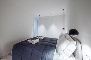 a bedroom with a blue bed with a stuffed animal on it at Vittoria Apt Luxury e Design in Duomo in Brescia