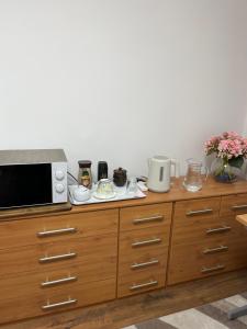 a microwave oven sitting on top of a wooden cabinet at House in city centre with free parking in Cambridge