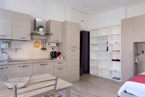a kitchen with white cabinets and a table in a room at Metro&Mare House in Lido di Ostia