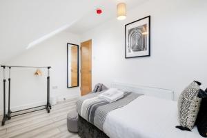 アイバーにあるBright 6 bedroom 3 bath house ideal for Pinewood Studiosの白い壁のベッドルーム1室(大型ベッド1台付)