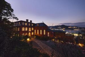 a large building with lights on it at night at Hotel Indigo Nagasaki Glover Street by IHG in Nagasaki +100 photos