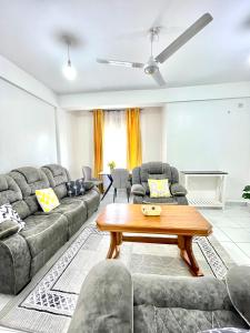 una sala de estar con un sofá y una mesa en Comfort Home Two Bedroom Buxton point Mombasa, en Mombasa