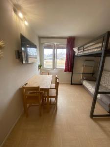 ein Zimmer mit Esstisch und Etagenbett in der Unterkunft Studio au pied des pistes in Le Dévoluy