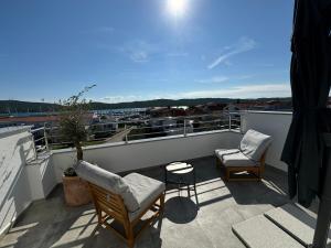 a balcony with two chairs and a table at Babin bed&breakfast in Pirovac