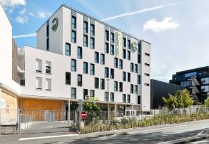 een wit gebouw met een bord aan de zijkant bij B&B HOTEL Champigny-sur-Marne in Champigny-sur-Marne